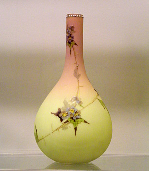 [Vase has a thin neck which opens to a globular bottom. The upper part is rose-colored while the lower is green. There is a flower pattern on the vase in several places.]